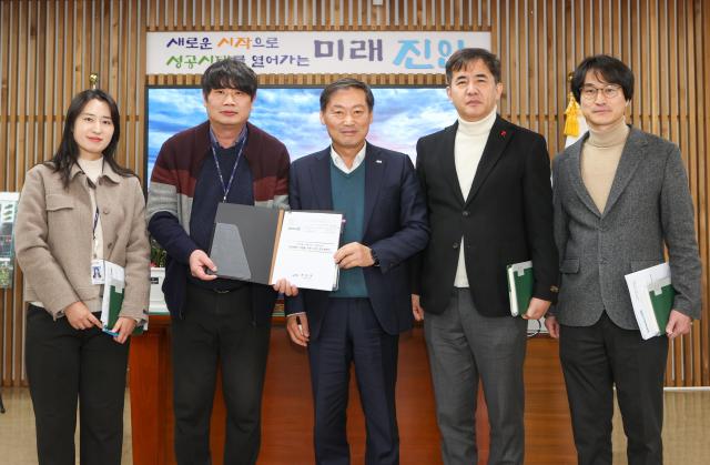 전춘성 진안군수가운데가 새해 첫 결재로 ‘기본소득 시범사업 기본계획 수립’을 선택하고 직원들과 포즈를 취하고 있다사진진안군