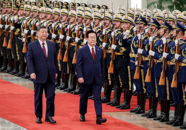 Lee Jae-myung and Xi Jinping review an honor guard during an official welcoming ceremony for Lee at the Great Hall of the People in Beijing on Jan 5 2026 Yonhap