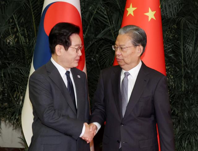 중국을 국빈방문 중인 이재명 대통령이 6일 베이징 인민대회당에서 국회의장 격인 자오러지 전국인민대표대회 상무위원장과 악수하고 있다사진연합뉴스