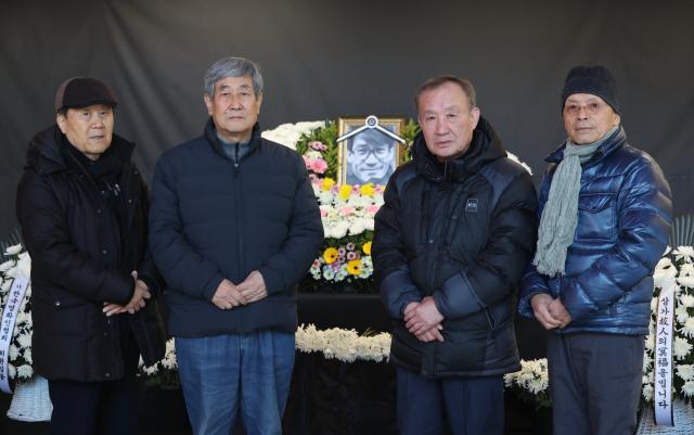 Director Hwang Dong-joo from left who served as assistant director for the 1962 film New Employee Mr Lee starring Ahn Sung-ki along with film industry veterans Lee Bok-yong producer Jo Byung-goo cinematographer and Park Gye-bong producer pose for a photo with the portrait of the late Ahn Sung-ki at the memorial space at the Seoul Cinema Center in Jung-gu Seoul Jan 7 2026 AJP Han Jun-gu