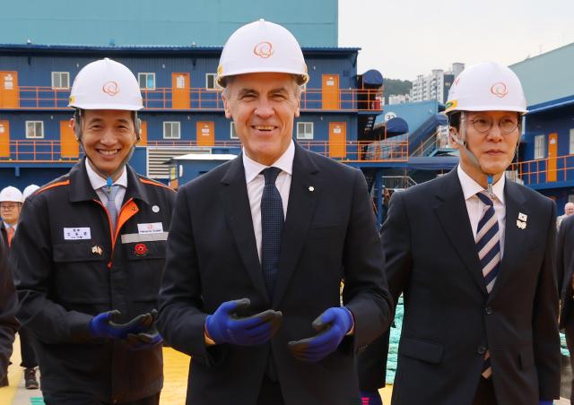 Prime Minister Kim Min-seok and Canadian Prime Minister Mark Carney visit Hanwha Ocean’s Geoje Shipyard in South Gyeongsang Province on October 30 2025 At left is Hanwha Group Vice Chairman Kim Dong-kwan Yonhap 