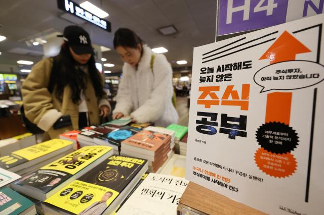 Visitors browse books at the stock investment section of a bookstore in Seoul. Yonhap