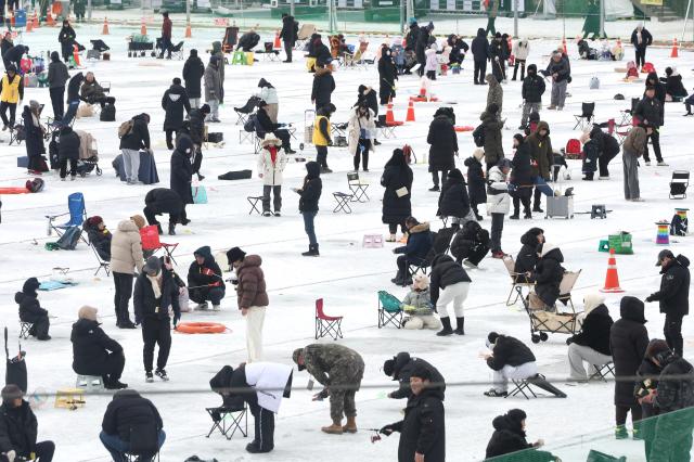 Visitors try ice fishing across the frozen ice field at the Hwacheon Sancheoneo Ice Festival in Hwacheon Gangwon Province Jan 12 2026 AJP Han Jun-gu