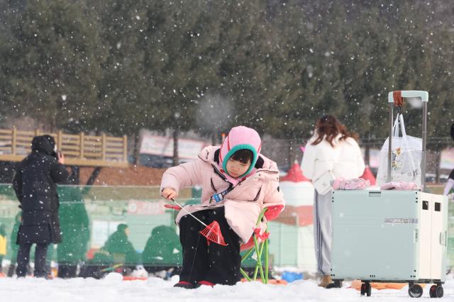 A child tries ice fishing at the Hwacheon Sancheoneo Ice Festival in Hwacheon Gangwon Province Jan 12 2026 AJP Han Jun-gu