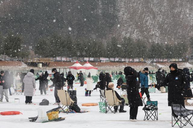 Visitors try ice fishing across the frozen ice field at the Hwacheon Sancheoneo Ice Festival in Hwacheon Gangwon Province Jan 12 2026 AJP Han Jun-gu