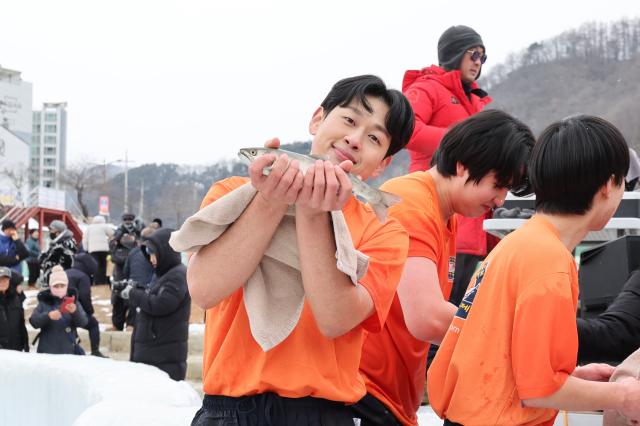 A participant holds a mountain trout after the bare-hand fishing competition at the Hwacheon Sancheoneo Ice Festival in Hwacheon Gangwon Province Jan 12 2026 AJP Han Jun-gu