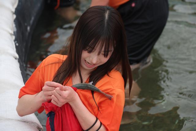 A participant stores a caught mountain trout inside her pocket during the bare-hand fishing competition at the Hwacheon Sancheoneo Ice Festival in Hwacheon Gangwon Province Jan 12 2026 AJP Han Jun-gu