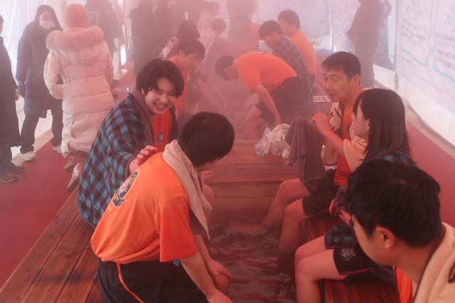 Participants warm their feet in a foot bath after the bare-hand fishing competition at the Hwacheon Sancheoneo Ice Festival in Hwacheon Gangwon Province Jan 12 2026 AJP Han Jun-gu