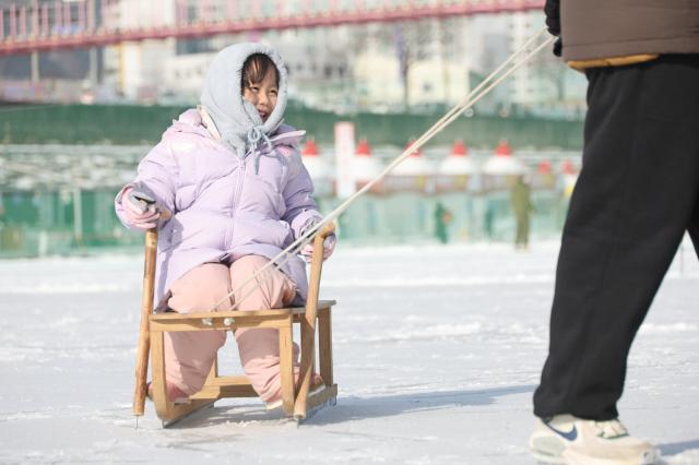A child rides a snow sled at the Hwacheon Sancheoneo Ice Festival in Hwacheon Gangwon Province Jan 12 2026 AJP Han Jun-gu