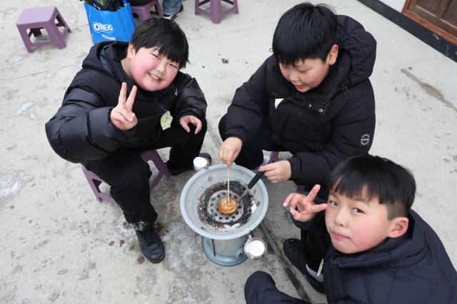 Children make dalgona sugar candy at a traditional game experience area at the Hwacheon Sancheoneo Ice Festival in Hwacheon Gangwon Province Jan 12 2026 AJP Han Jun-gu