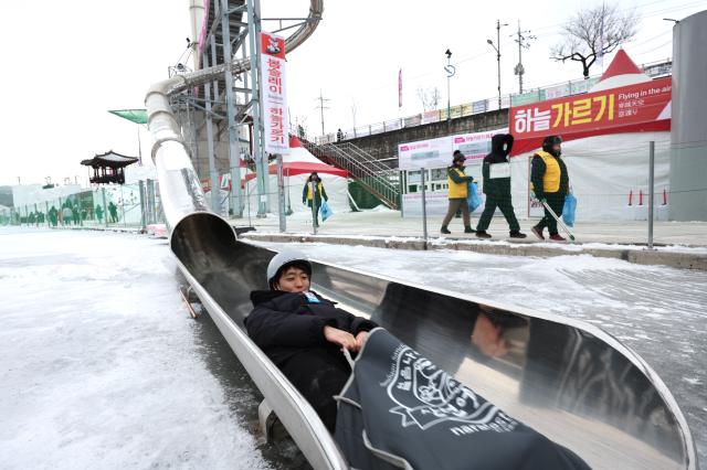 A visitor rides down a slide at the Hwacheon Sancheoneo Ice Festival in Hwacheon Gangwon Province Jan 12 2026 AJP Han Jun-gu