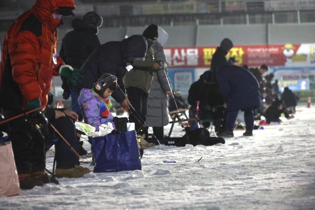 Visitors try ice fishing at night at the Hwacheon Sancheoneo Ice Festival in Hwacheon Gangwon Province Jan 12 2026 AJP Han Jun-gu