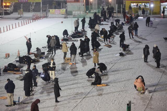 Visitors try ice fishing at night at the Hwacheon Sancheoneo Ice Festival in Hwacheon Gangwon Province Jan 12 2026 AJP Han Jun-gu