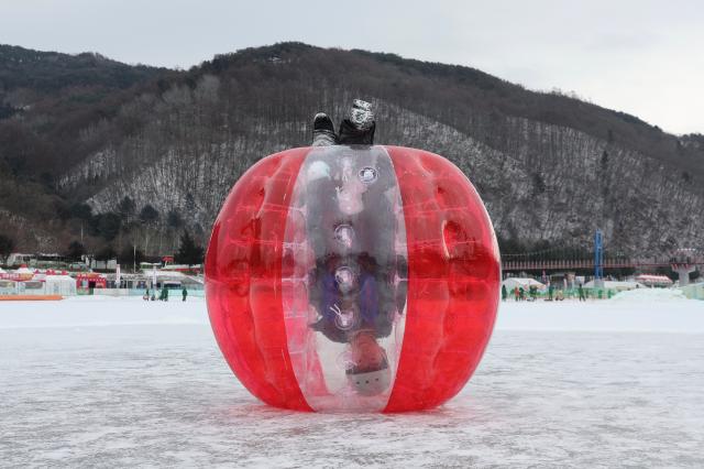 A child plays inside a bubble suit on the ice at the Hwacheon Sancheoneo Ice Festival in Hwacheon Gangwon Province Jan 12 2026 AJP Han Jun-gu