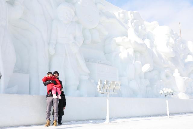 Visitors poses for a photo in front of giant ice sculptures at the Hwacheon Sancheoneo Ice Festival in Hwacheon Gangwon Province Jan 12 2026 AJP Han Jun-gu