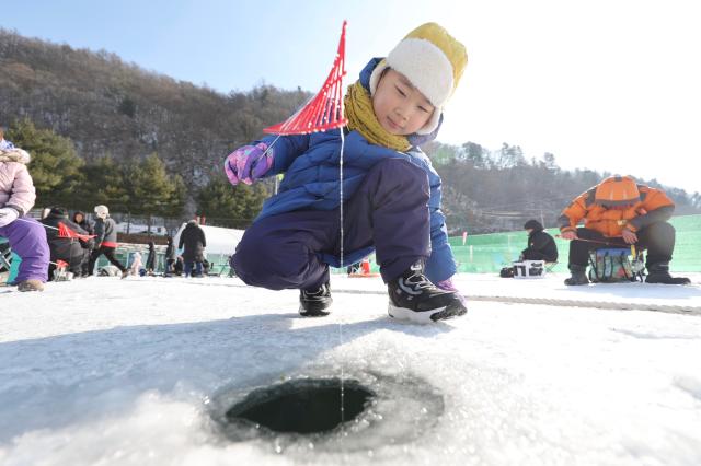 A child tries ice fishing at the Hwacheon Sancheoneo Ice Festival in Hwacheon Gangwon Province Jan 12 2026 AJP Han Jun-gu