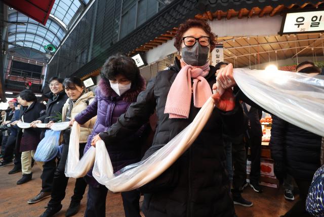 Merchants and citizens make a 180-meter-long garaetteok Korean rice cake at a rice cake sharing event held at Motgol Market in Paldal Suwon Gyeonggi Province Jan 16 2026