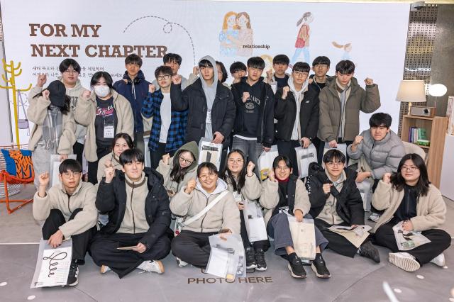 T팩토리 성수를 방문한 학생들과 선생님들이 기념 촬영을 하고 있는 모습사진SKT