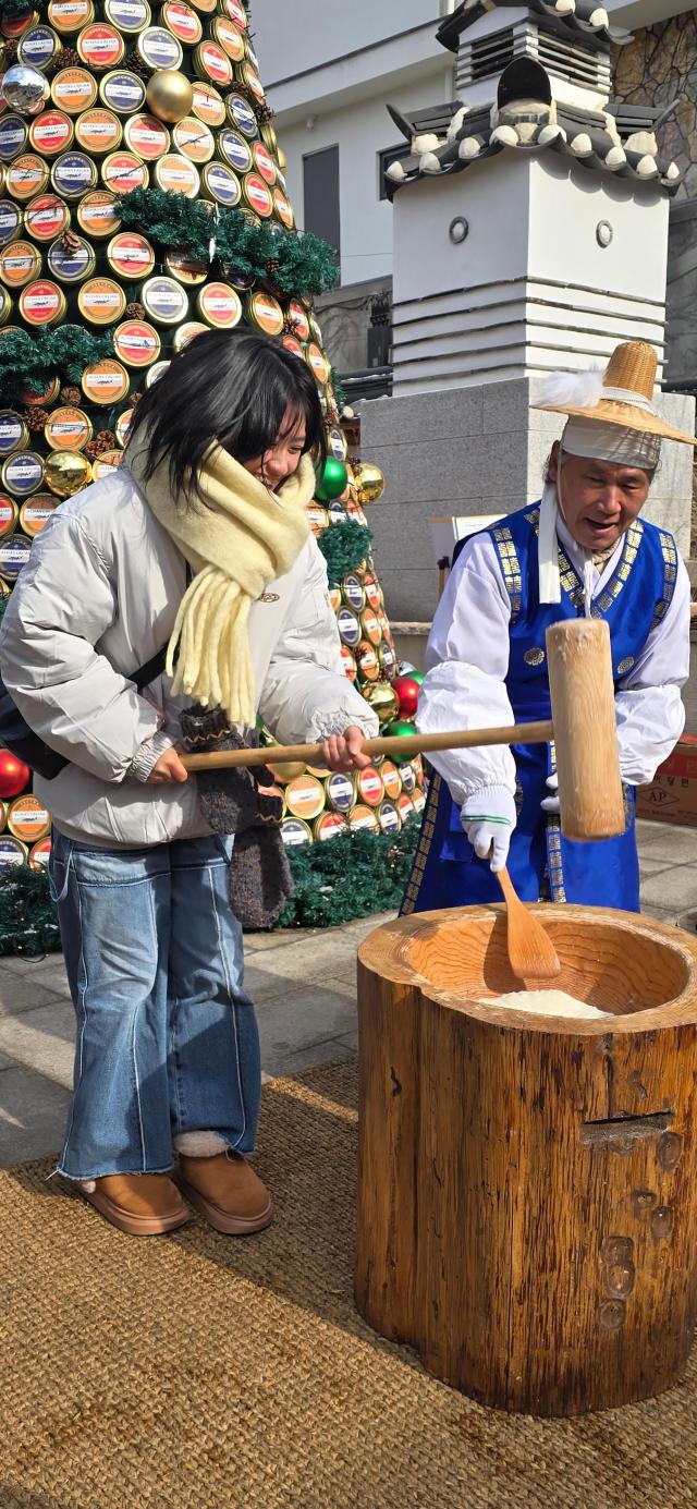 19일 오전 서울 북촌 와이레스YLESS 입구에서 한 외국인 여행객이 떡메치기 체험을 하고 있다 사진기수정 기자