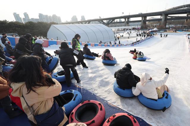 Visitors enjoy snow tubing at a snow sledding area in Ttukseom Seoul Jan 19 2026 AJP Han Jun-gu