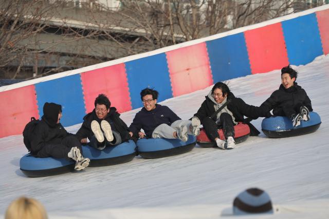 Visitors enjoy snow tubing at a snow sledding area in Ttukseom Seoul Jan 19 2026 AJP Han Jun-gu