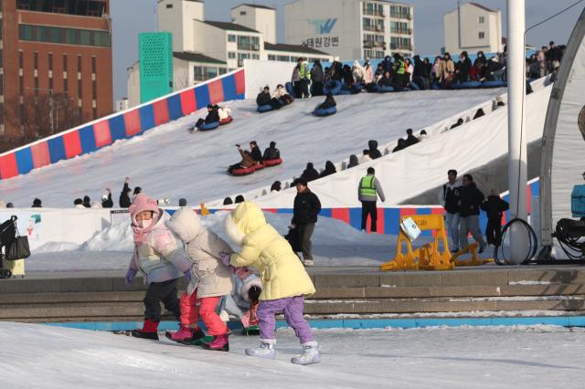 Visitors play at a snow sledding area in Ttukseom Seoul Jan 19 2026 AJP Han Jun-gu
