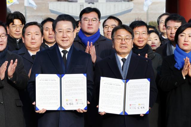 Gwangju Mayor Kang Gi-jung and South Jeolla Province Governor Kim Yung-rok pose for a commemorative photo after announcing the Gwangju–South Jeolla administrative integration declaration at the May 18th National Cemetery in Buk-gu Gwangju on Jan 2 2026 Yonhap 