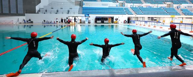 Rescue team members from Incheon Bupyeong Fire Station conduct winter water rescue training at the diving pool of Munhak Park Tae-hwan Swimming Pool in Michuhol-gu Incheon on Jan 21