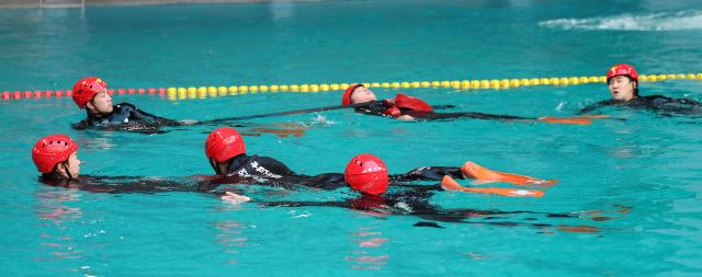 Rescue team members from Incheon Bupyeong Fire Station conduct winter water rescue training at the diving pool of Munhak Park Tae-hwan Swimming Pool in Michuhol-gu Incheon on Jan 21