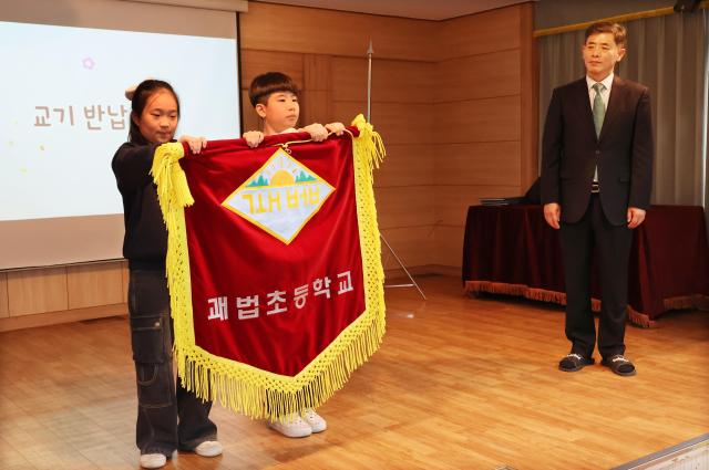 Students return the school flag during a farewell ceremony at Gwabeop Elementary School in Sasang-gu Busan on Jan 20 Yonhap