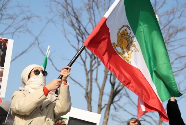 내한이란인 네트워크가 지난 17일 서울 종로구 광화문광장 인근에서 미국 정부의 이란 군사 개입을 촉구하며 팔레비 왕조 시절 이란 국기를 흔들고 있다 사진연합뉴스