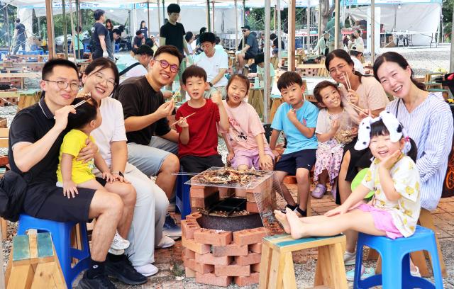 지난해 열린 완주와일드로컬푸드축제에서 참가자들이 물고기 굽기 체험을 하며 즐거워하고 있다사진완주군