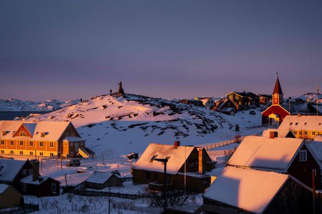 A statue of Hans Egede a Dano-Norwegian Lutheran missionary is pictured next to the Cathedral R on the top of a hill covered by snow at sunset light in Nuuk Greenland on Jan 21 2026 AFP-Yonhap