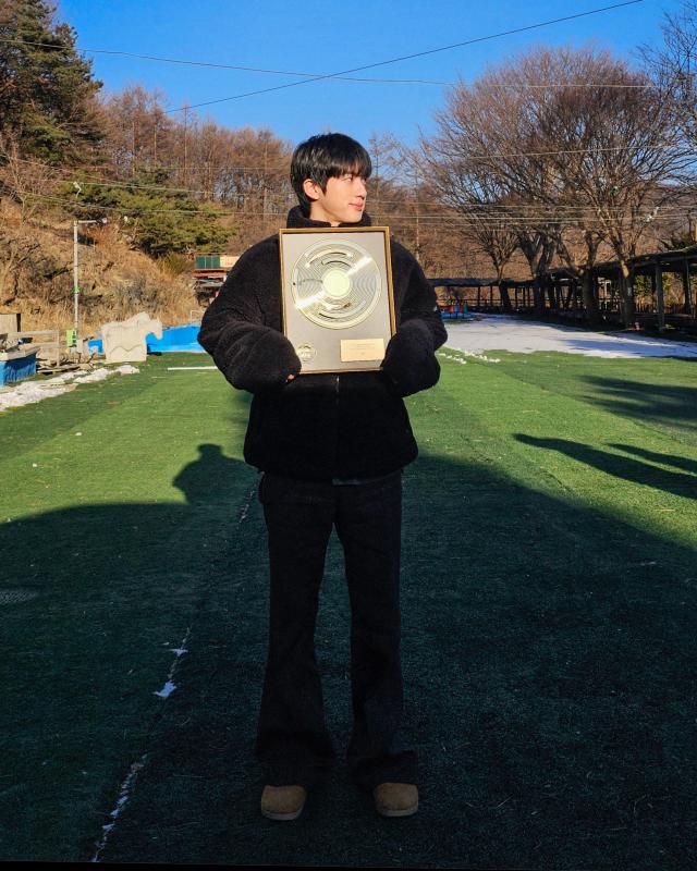 This photo captured from WEVERSE show BTS Jin holding up his plaque for 'Upbit Male Popularity Award' from 41st golden disk award