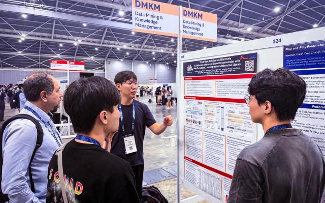 지난 24일 싱가포르에서 열린 ‘AAAI 2026’에서 포스터 앞 왼쪽부터 김태산 · 윤형준 SKT 데이터분석모델링팀 매니저가 ‘One Model’ 버전 40 연구에 대해 ‘포스터 발표Poster Session’ 중인 모습사진SKT