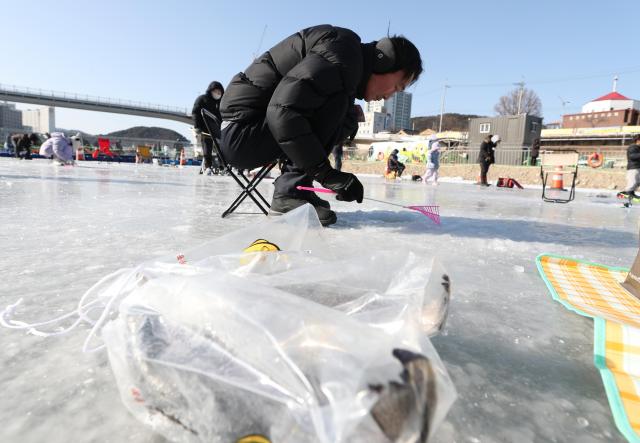 A visitor experiences ice fishing at the 2026 Hongcheon Kkongkkong Festival in Hongcheon Gangwon Province Jan 25 2026 Yonhap