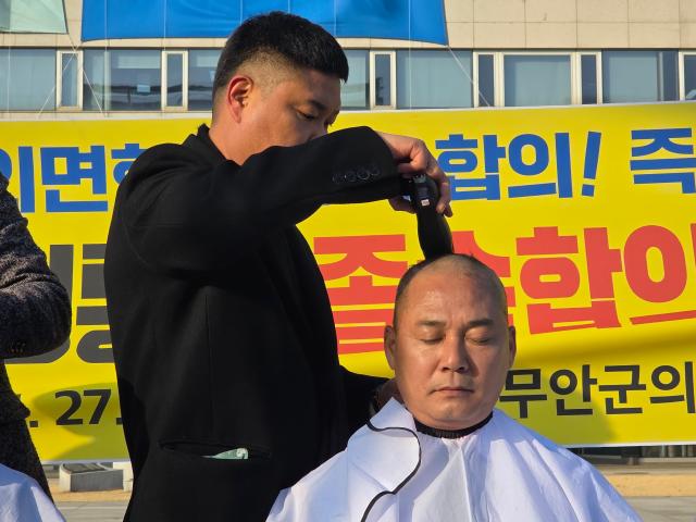 무안군의회 이호성 의장이 27일 오후 전남도청 앞에서 삭발식을 갖고 전남·광주 행정통합을 둘러싼 졸속 합의를 강하게 규탄했다사진김옥현기자