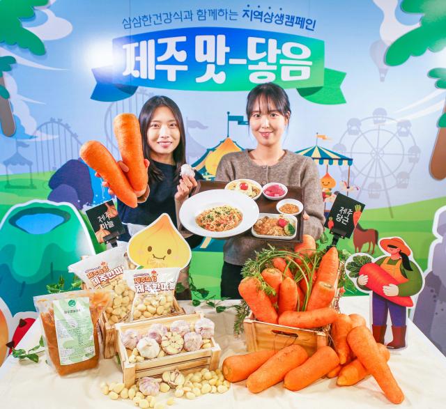 현대그린푸드 직원들이 제주산 당근과 남도종 마늘을 활용해 만든 이색 급식 메뉴인 당근명란오일파스타와 마늘소스 허브닭구이를 소개하고 있는 모습 사진현대그린푸드