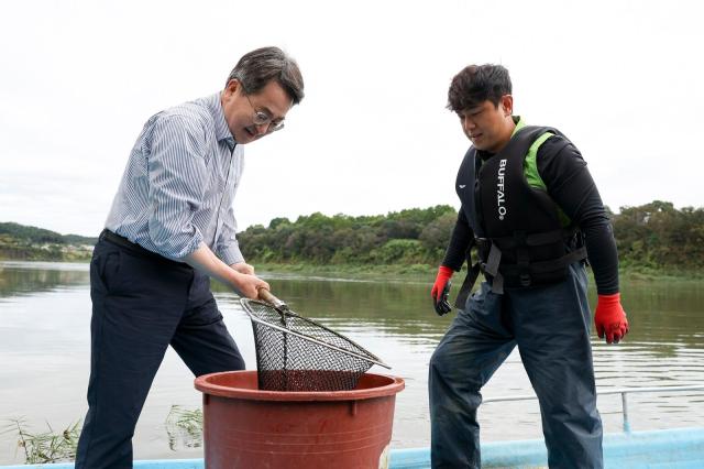 10월 14일 김동연 지사가 한탄강에서 청년어부와 참게를 옮기고 있다 사진경기도