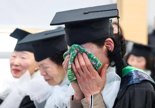 An adult graduate wipes away tears during the 2025 Neulpureum School elementary and middle school graduation ceremony at the annex building of Yeongdeungpo District Office in Seoul on Jan 28 Yonhap
