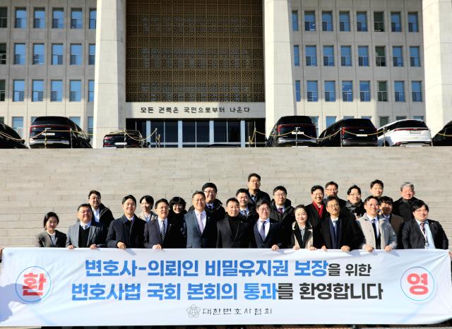 변호사-의뢰인 간 비밀유지권 제도를 도입한 변호사법 개정안이 29일 국회 본회의를 통과한 가운데 대한변호사협회 김정욱 협회장과 서울지방변호사회 조순열 회장 김용민 의원 등 관계자들이 국회 앞에서 기념촬영을 하고 있다 사진대한변협