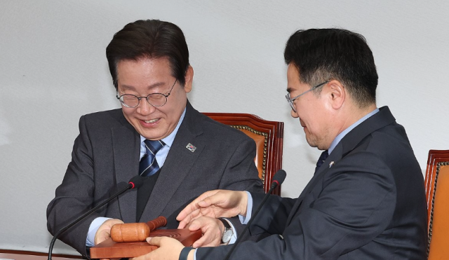 이재명 당시 더불어민주당 대표가 지난해 4월 9일 서울 여의도 국회에서 열린 최고위원회의에서 사퇴 의사를 밝힌 뒤 대표 직무대행을 맡은 박찬대 원내대표에게 의사봉을 넘기고 있다 사진연합뉴스

