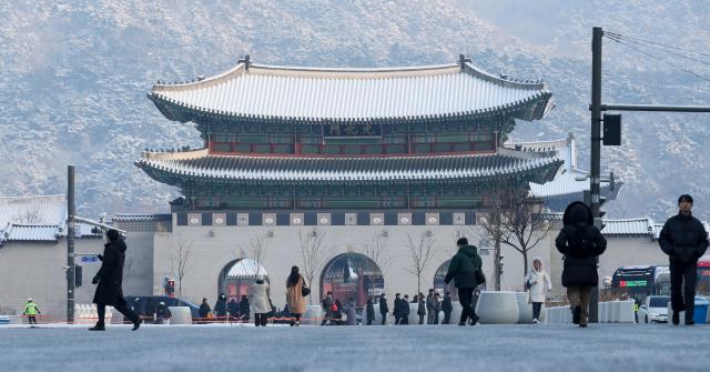 Commuters walk near Gwanghwamun in Seoul on Feb 2 as snow that fell overnight remains on the ground AJP Yoo Na-hyun