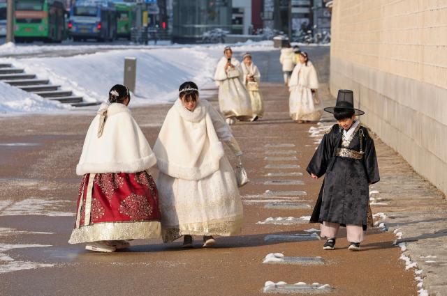 Tourists walk near Gyeongbokgung in Seoul as snow that fell overnight remains on the ground, Feb. 2. AJP Yoo Na-hyun