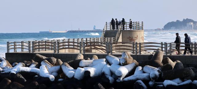 Prolonged cold weather continues as visitors watch the sea at Gangmun Beach in Gangneung Gangwon Province on Jan 25 2026 Yonhap
