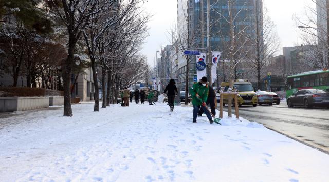 눈이 내려 쌓인 2일 오전 대전 서구 둔산동에서 서구청 관계자들이 제설작업을 하고 있다 사진연합뉴스