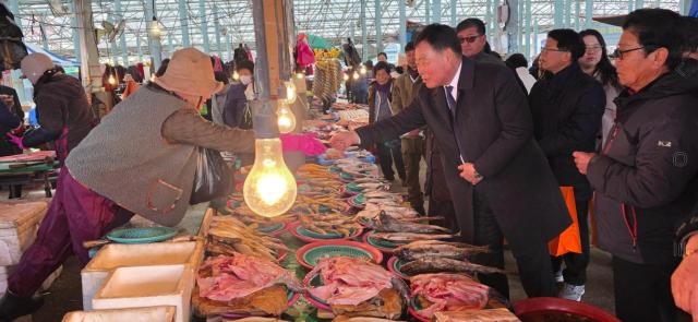 김산 무안군수가 설 명절을 앞두고 일로전통시장을 찾아 제수용품을 구매하며 상인들을 격려하고 있다 “전통시장이 살아야 지역경제가 산다”는 메시지를 현장에서 실천하는 모습이다사진김옥현기자