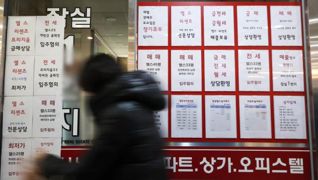 2월 8일 서울 잠실에 위치한 공인중개사 사무실 유리 벽에 부동산 관련 세금과 아파트 매매 물건 등의 안내문이 게시되어 있다사진연합뉴스
