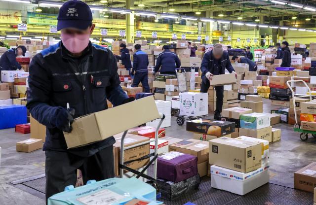 Workers sort parcel boxes at the Dongseoul Mail Logistics Center in Seoul’s Gwangjin Ward ahead of the Lunar New Year holiday on Feb 11 AJP Yoo Na-hyun