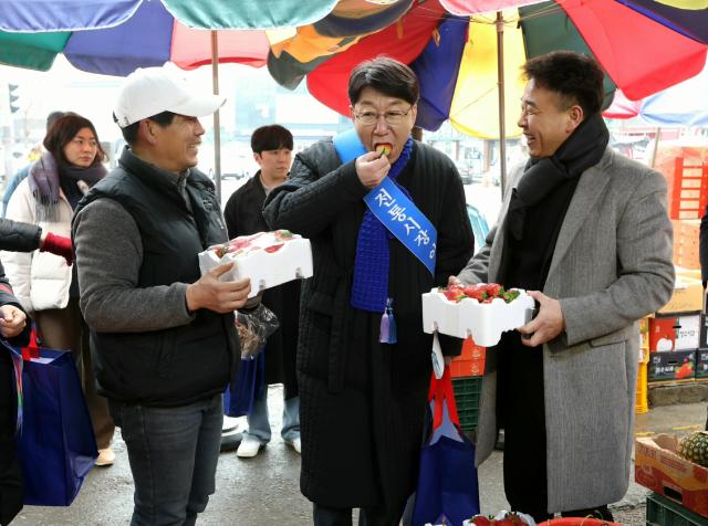 우범기 전주시장오른쪽 두 번째이 11일 전주 모래시장에서 진행된 전통시장 장보기 행사에서 구입한 딸기를 시식해보고 있다사진전주시